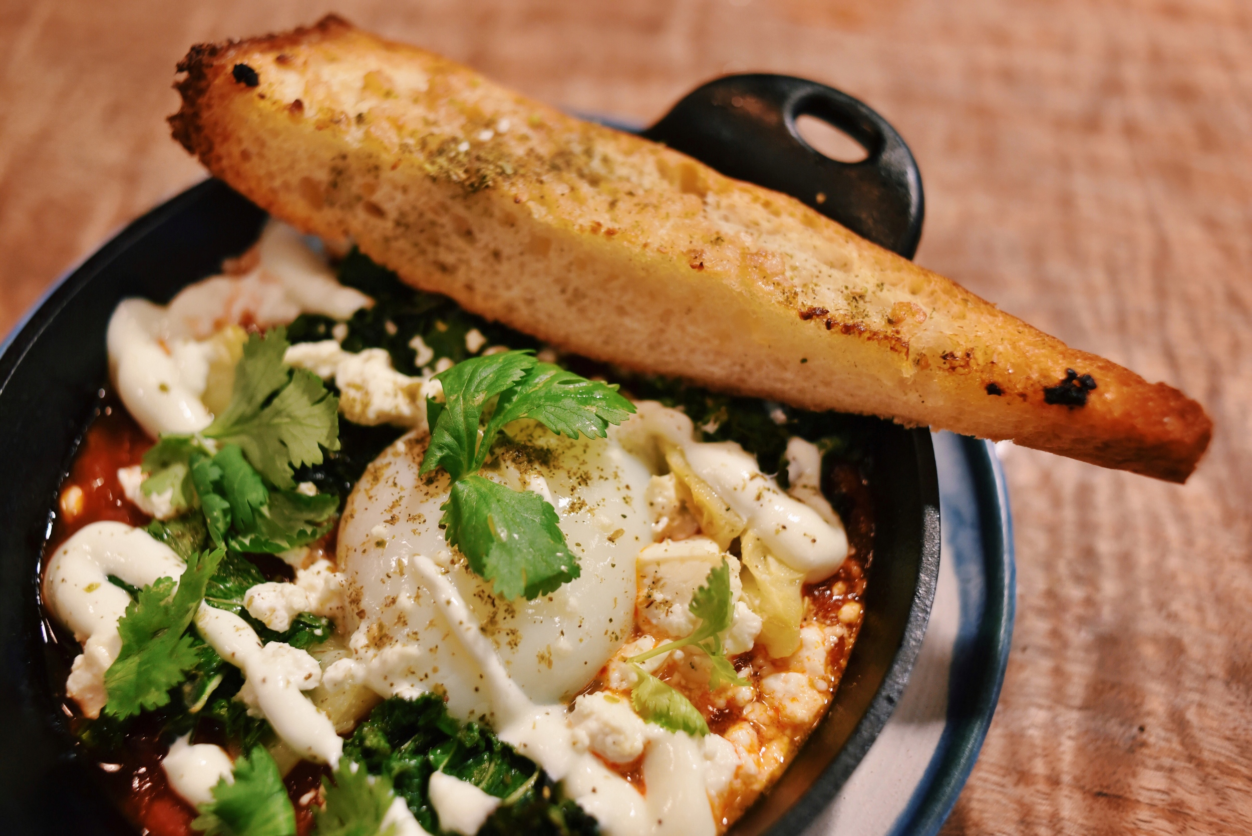 SUMMER SHAKSHUKA, spricy tomato & roast pepper sauce, zucchini, kale, soft egg, yogurt, zaatar baguette 