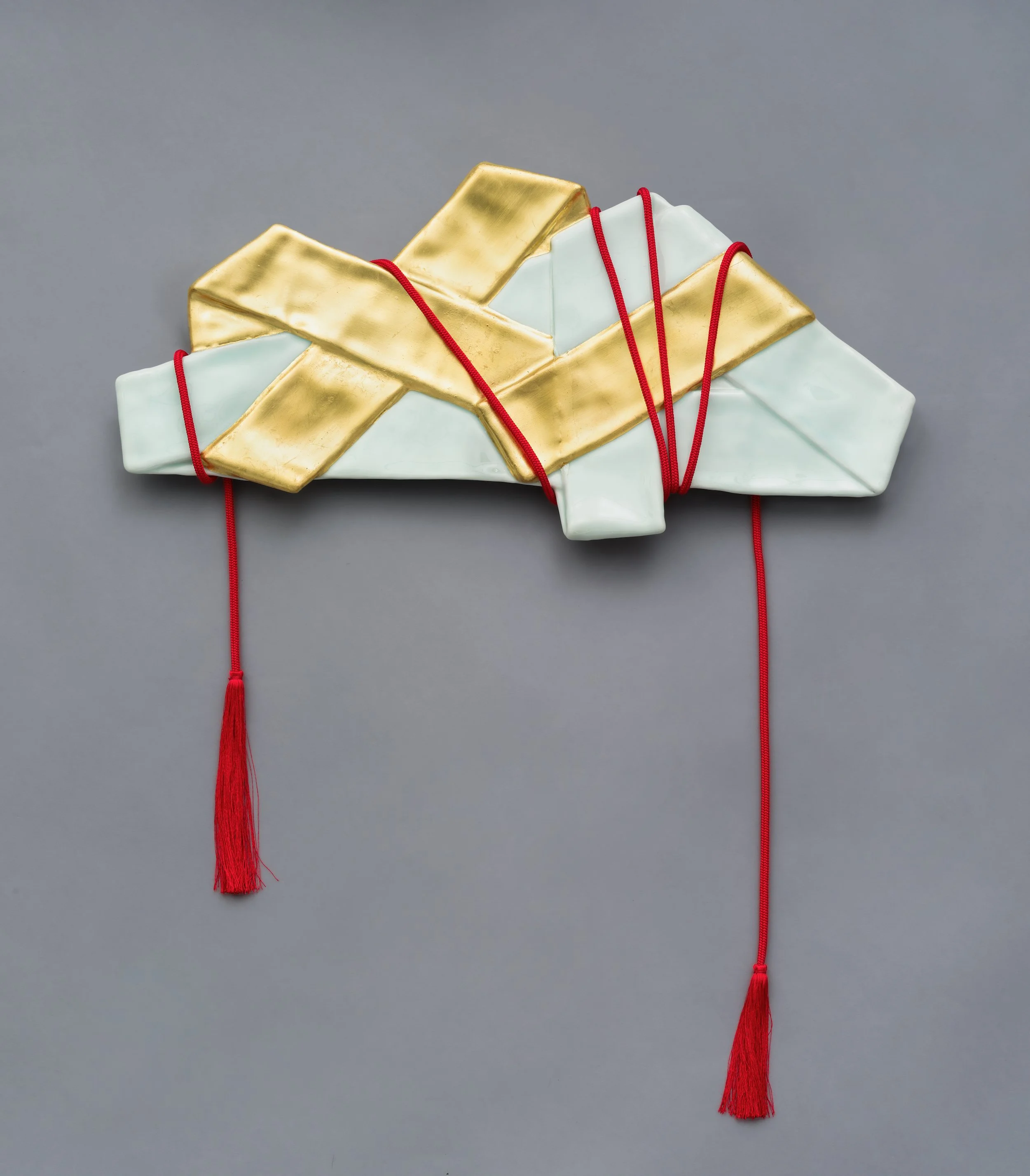   Tasuki/Sash I , 2024 23 x 20 x 1.5 inches Porcelain, Glaze, Gold Leaf, Silk Cord 