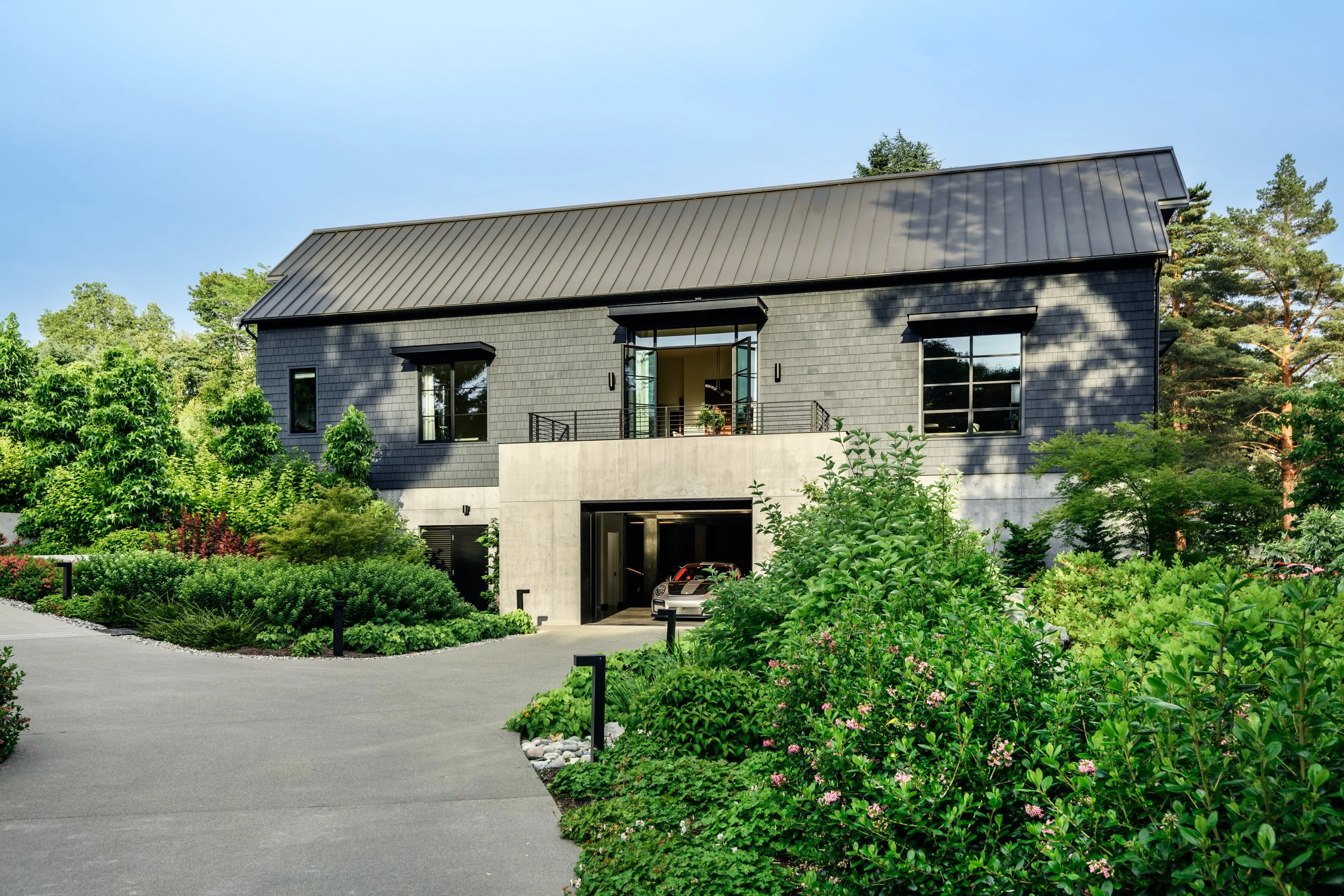Driveway edged by hydrangeas with sportscar.