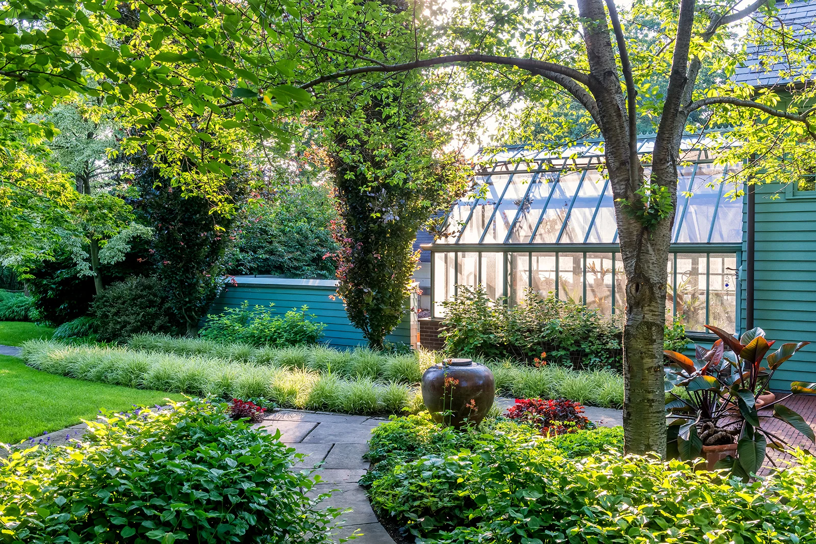 At Mountsier Garden in New Jersey Land Morphology's design of a simple border of Carex morrowii ' Ice Ballet,' with its white variegated leaves, which creates a strong plane that complements the narrow-growing copper beeches.