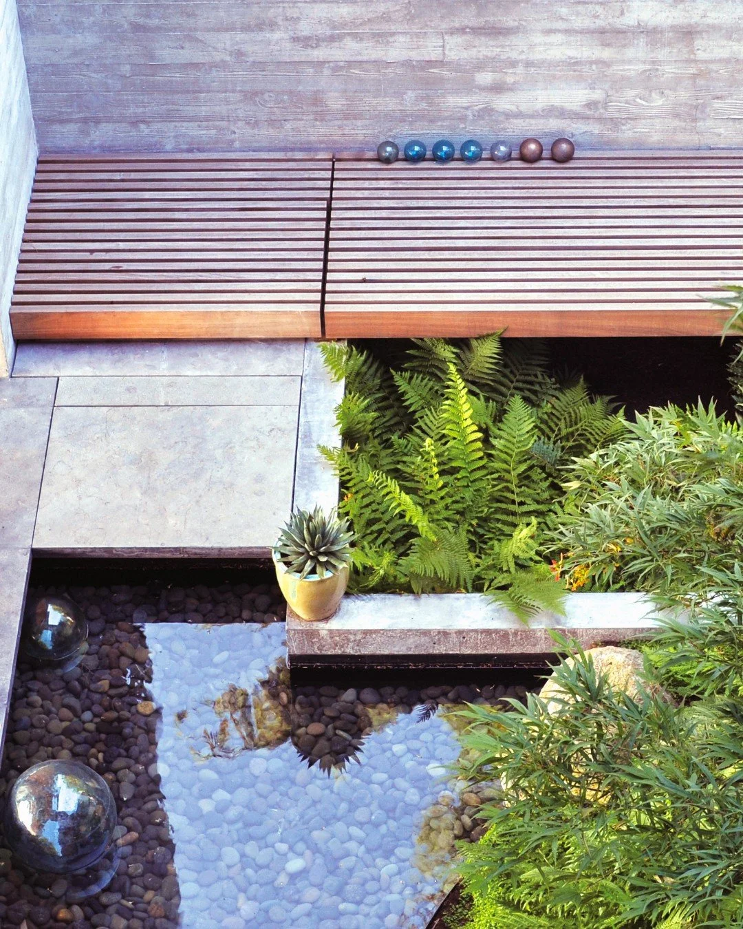 This view from inside and above captures the intimate courtyard at The Perch.  The garden tells a quiet story of the Pacific Northwest&mdash;layering metaphor and material to evoke our region&rsquo;s green forests, tidal waters, and mountainous terra