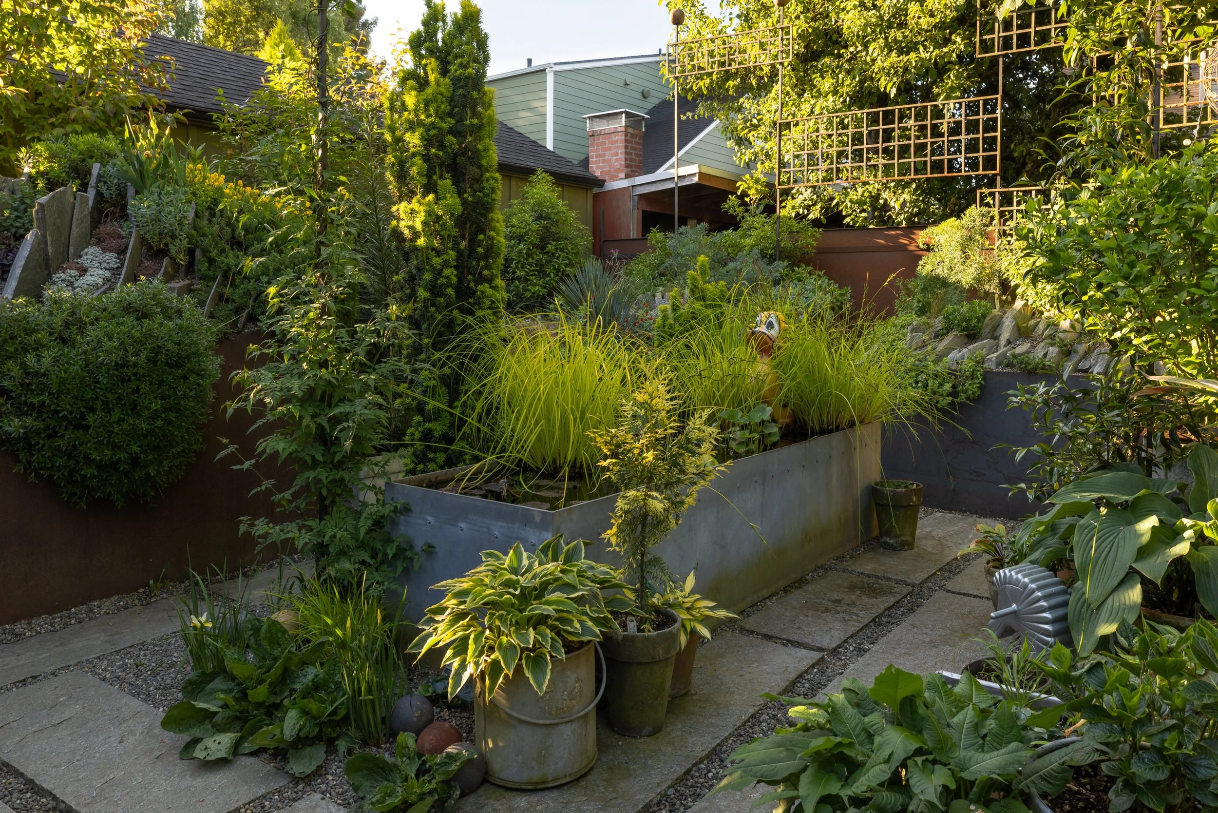 a view of the linear water feature with duck fountain, surrounded by potted plants