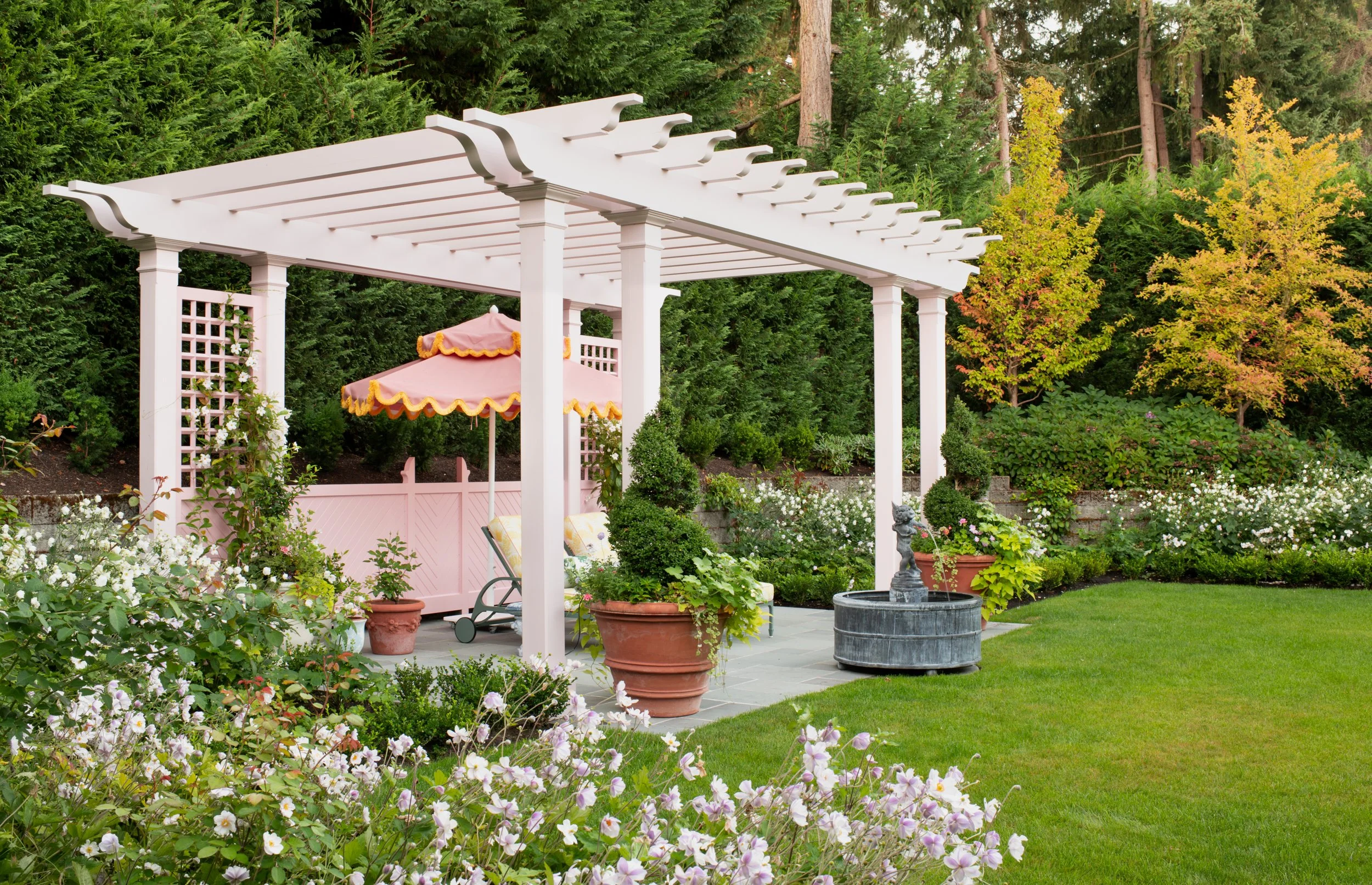 Side view of pink arbor with lush plantings