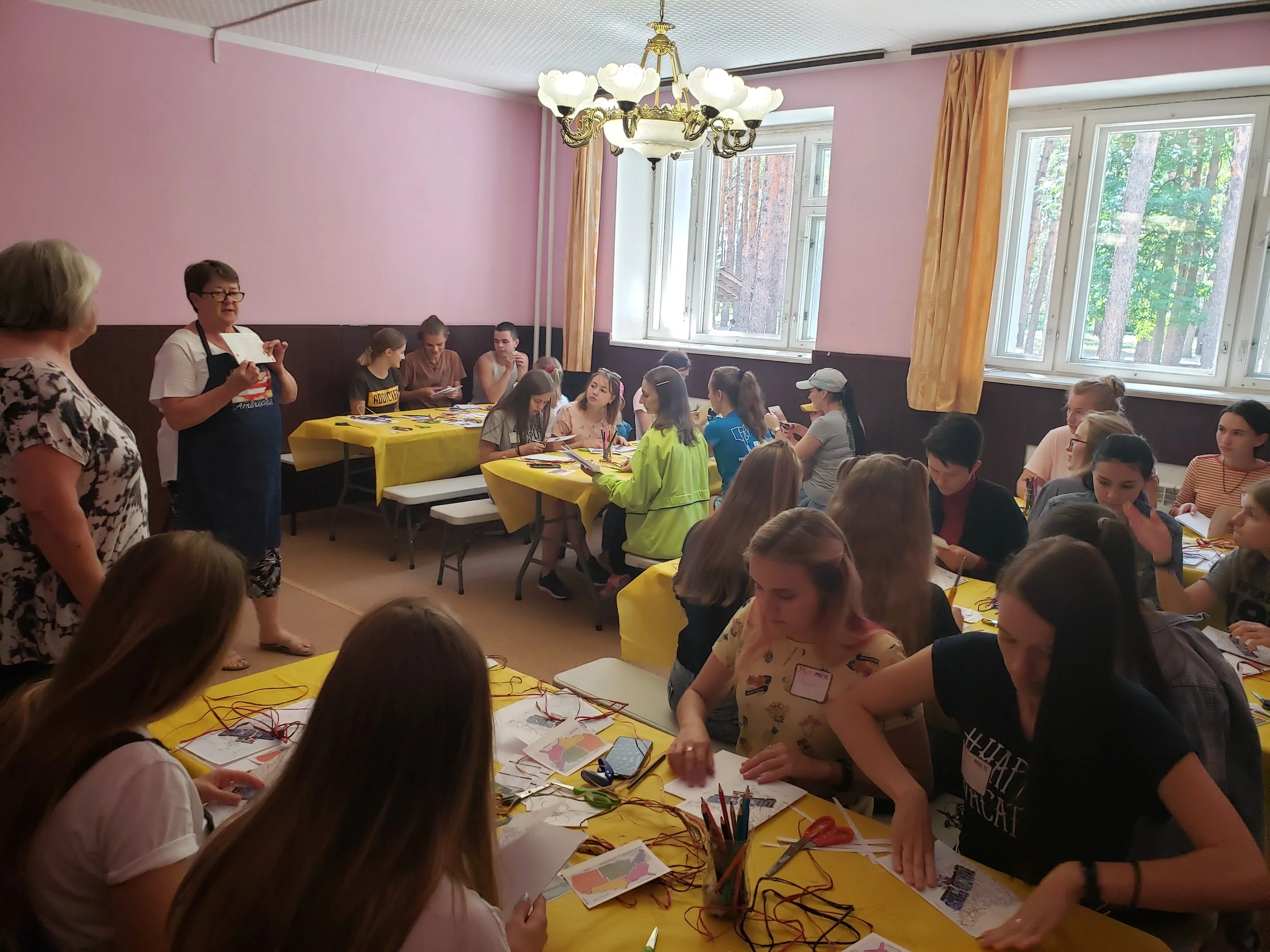 Becca kicking off the first day of crafts and showing students how to make journals