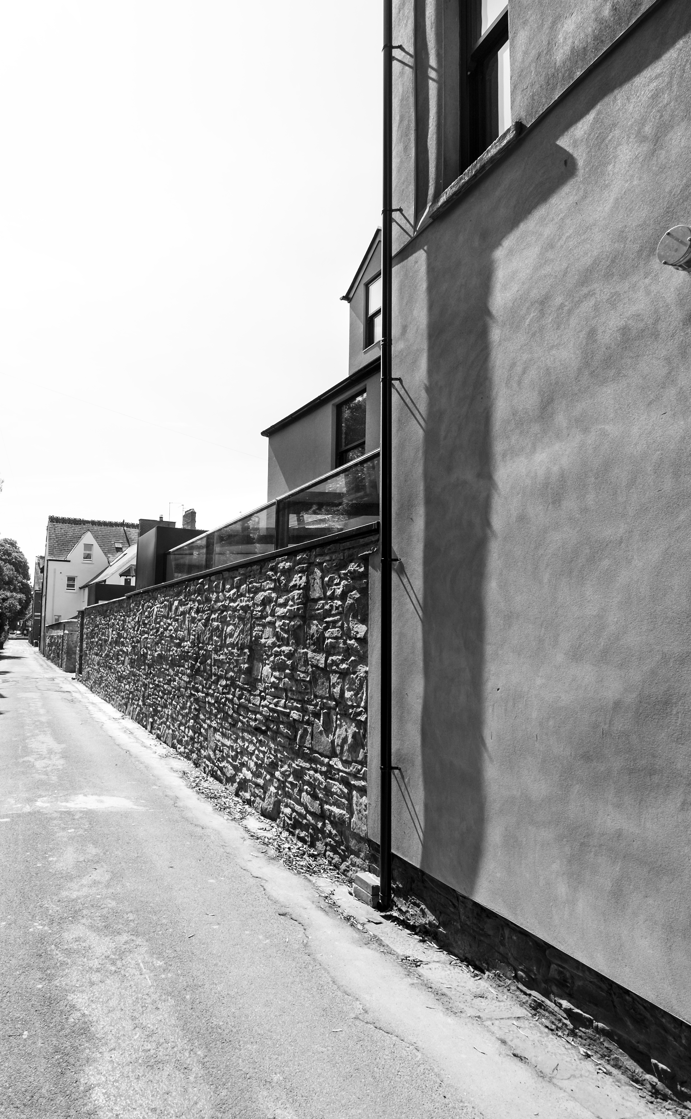  The dark aluminium and glass flat roof extension, sits neatly behind the reconstructed original stone wall. 