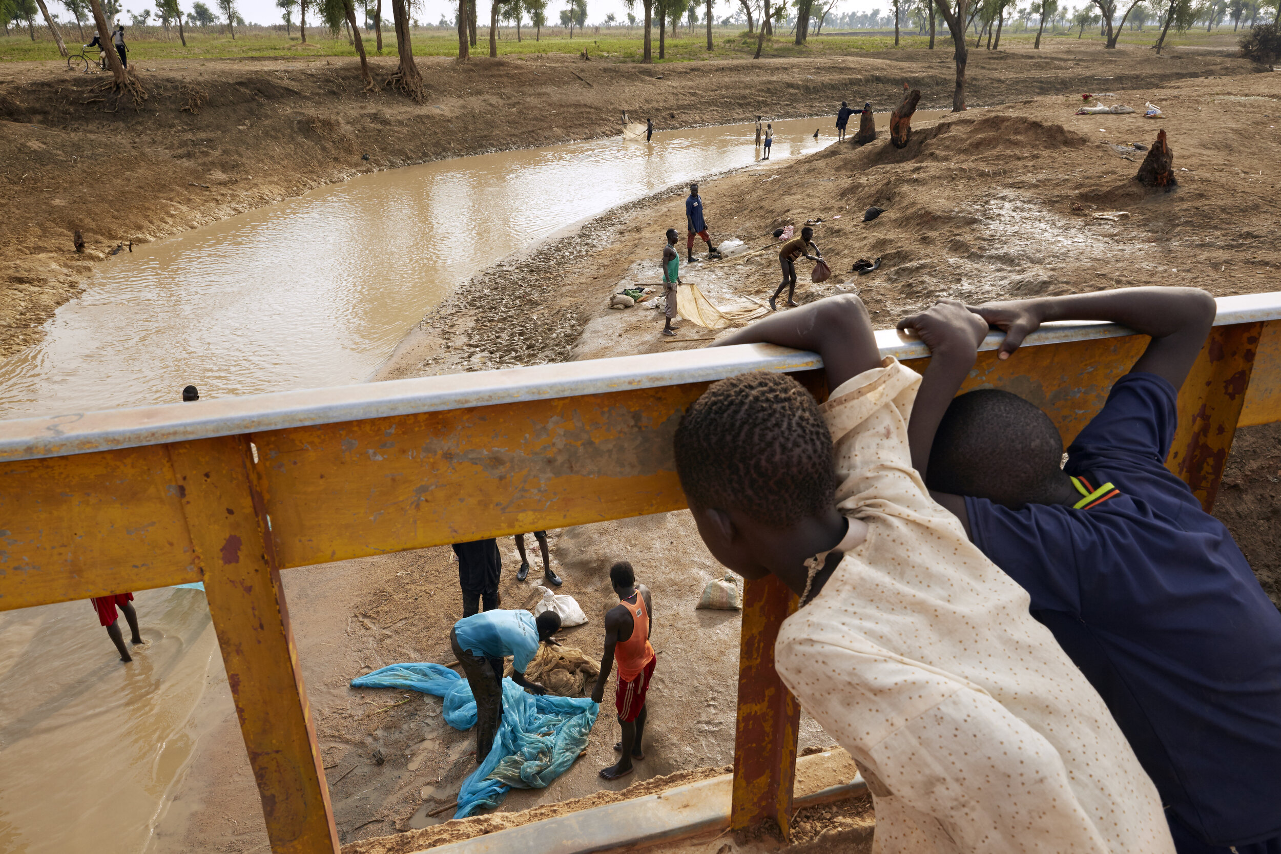 A boy watches fishermen fish in Maban, South Sudan