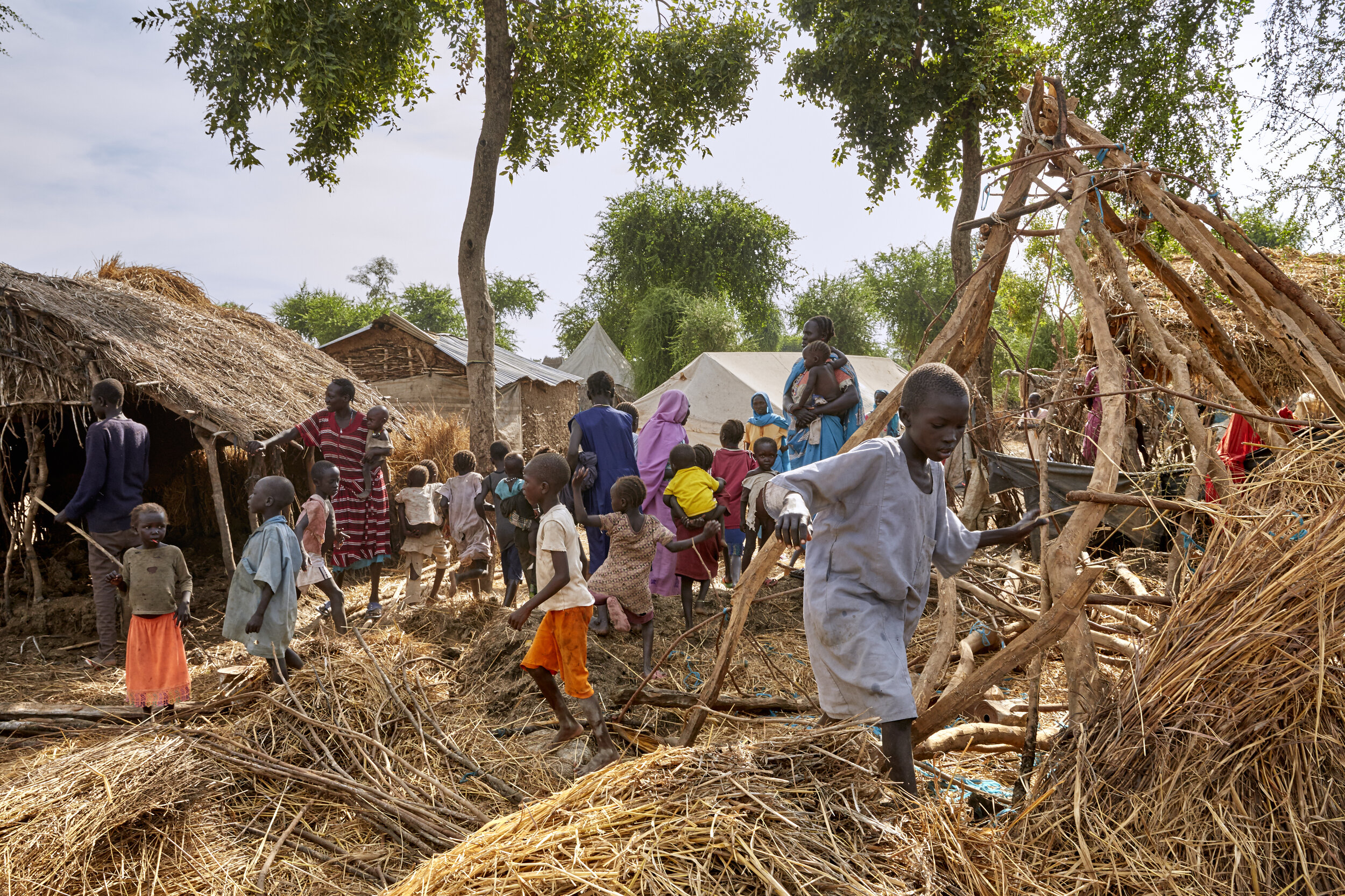 A boy steps over the remains of a destroyed home in a refugee camp in Maban, South Sudan 