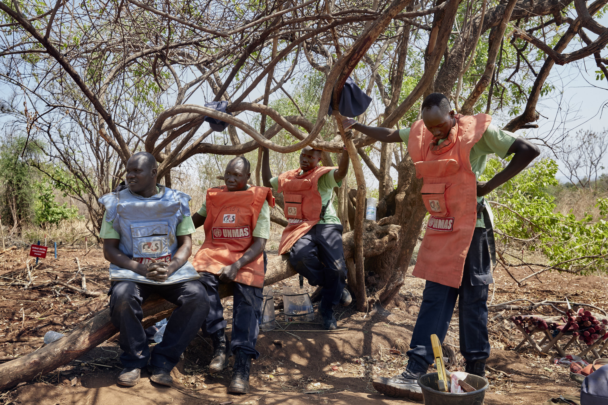 United Nations Mine Action Service workers take a break from searching for unexploded ordinance on the road between Nimule and Juba, South Sudan