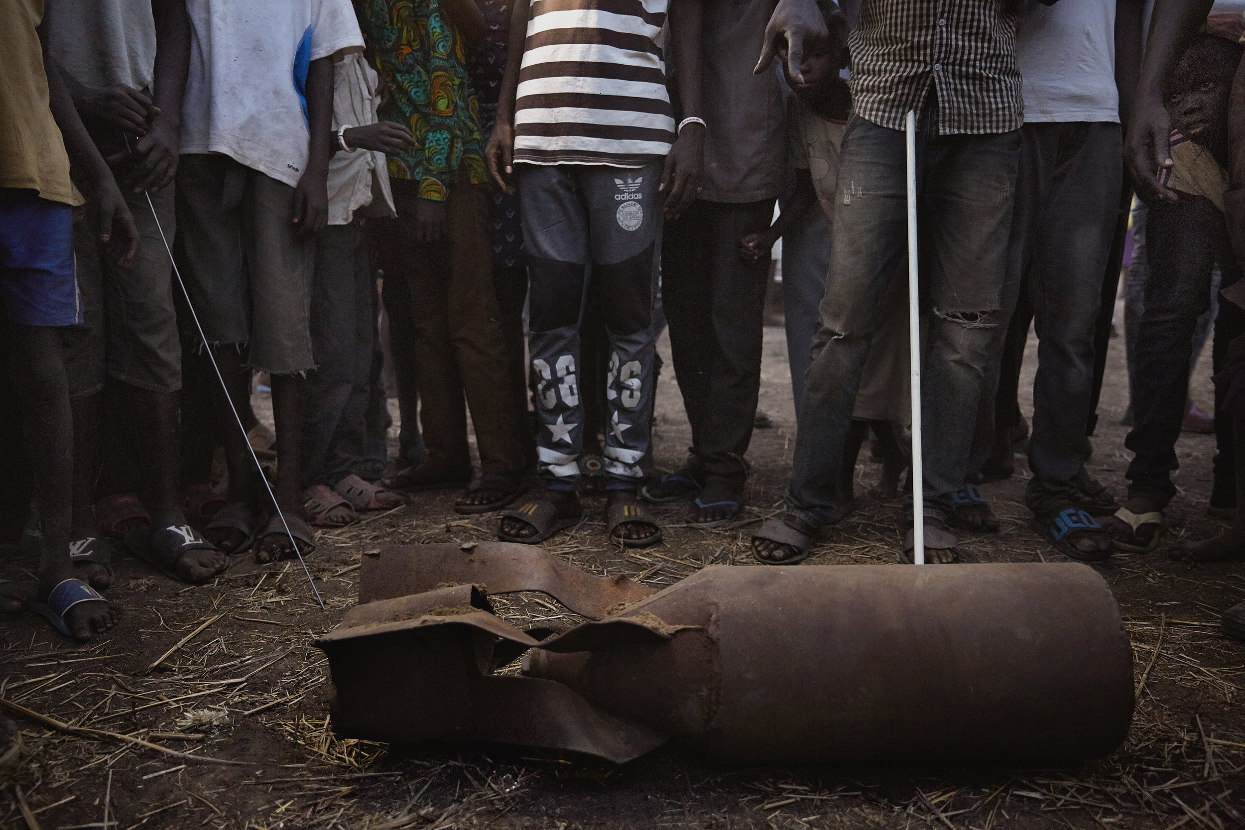 South Sudanese villagers gather around an unexploded bomb in Juba, South Sudan