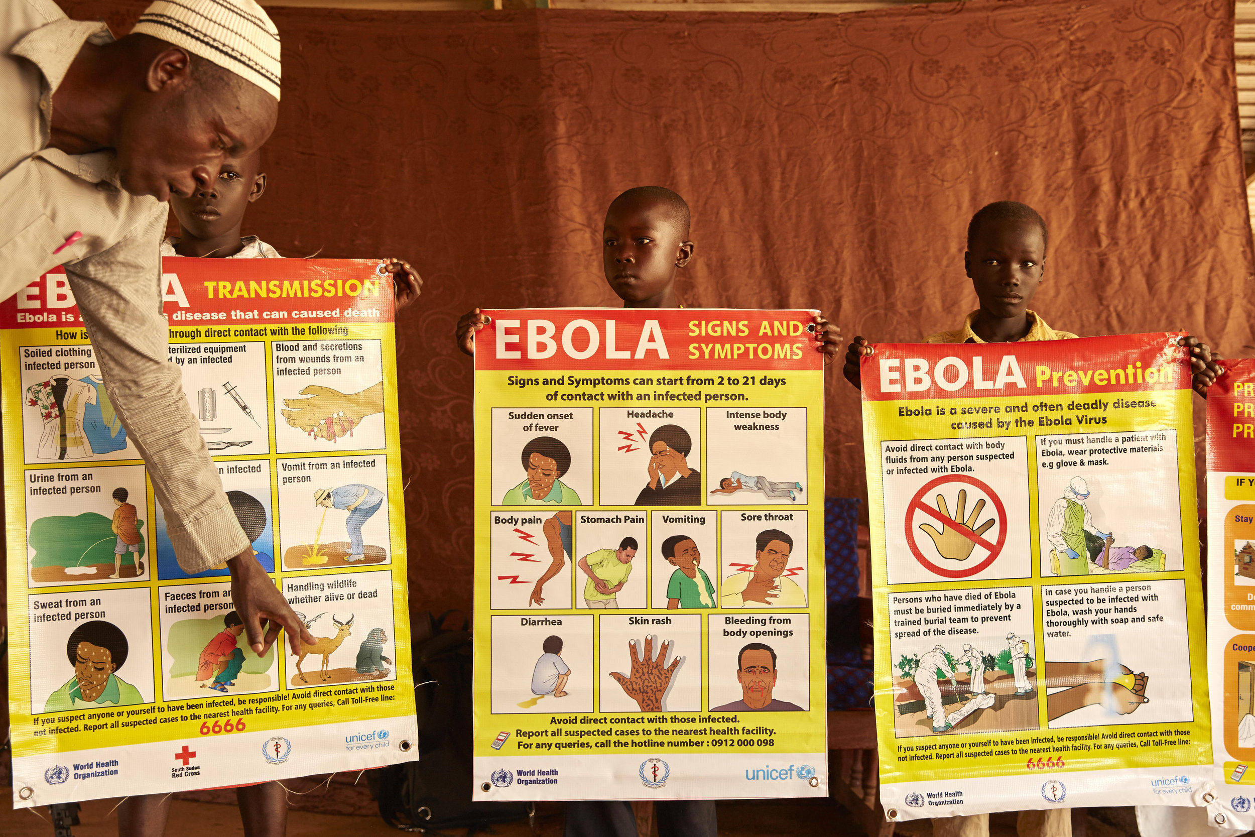 Boys hold up ebola prevention posters in Yei, South Sudan