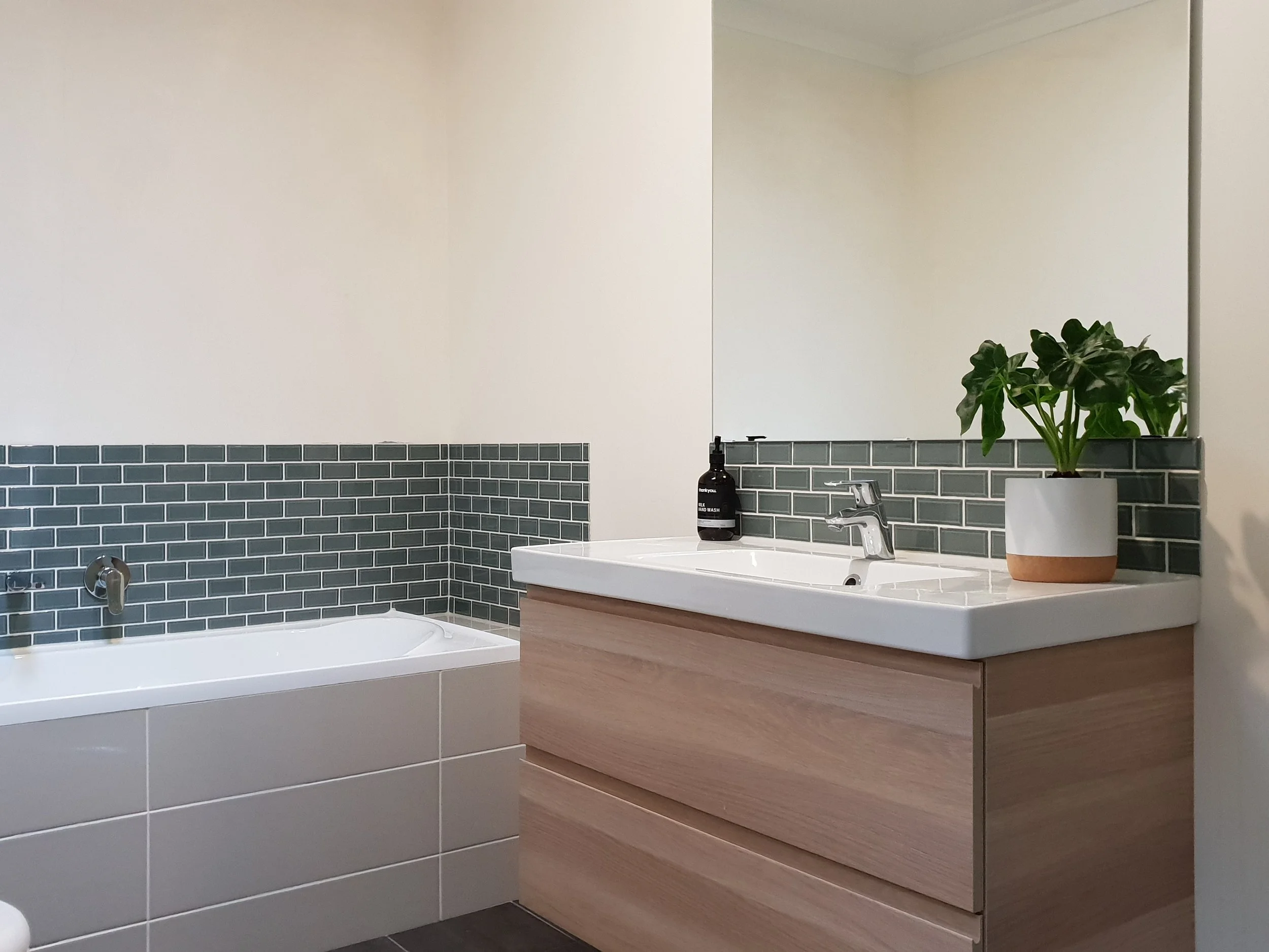 New plumbing fixtures, tapwear & a wall mounted vanities have replaced the old fittings in the main bathroom & are repeated in the new ensuite bathroom for consistancy. Glass mosaic tiles introduce a splash of colour to contrast with the otherwise neutral palette.