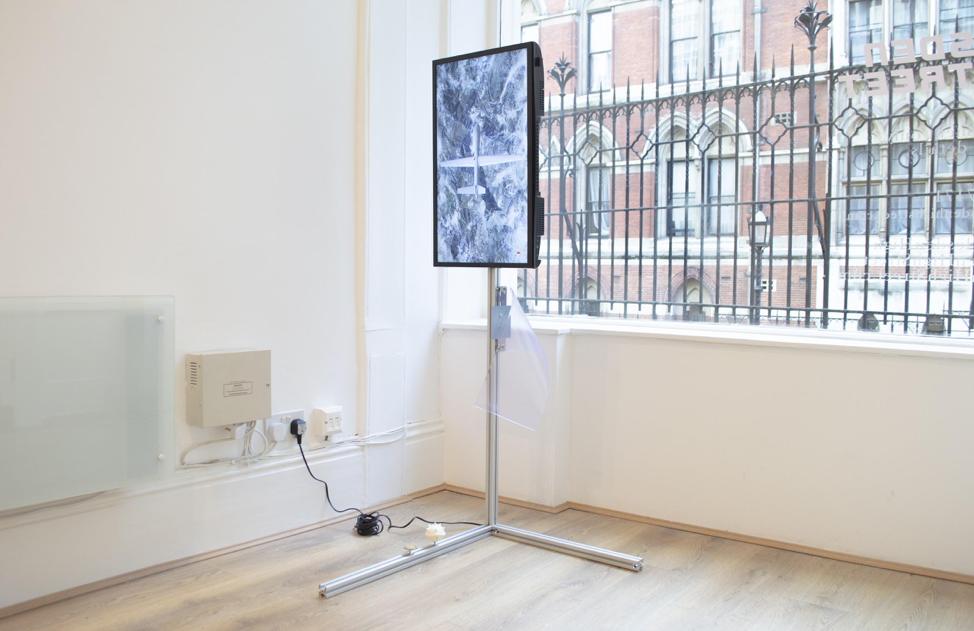 Drone Theory , 2018, HD digital video with sound, 5 min 9 sec, 28” LCD screen, aluminium modular system, print on aluminium, PVC, 3D printed polyamide, Donald Trump inauguration gold plated coin, custom USB drive, miscellaneous cables, screws, 147 x 88 x 54 cm, Edition of 1, 1AP. Image courtesy of the artist