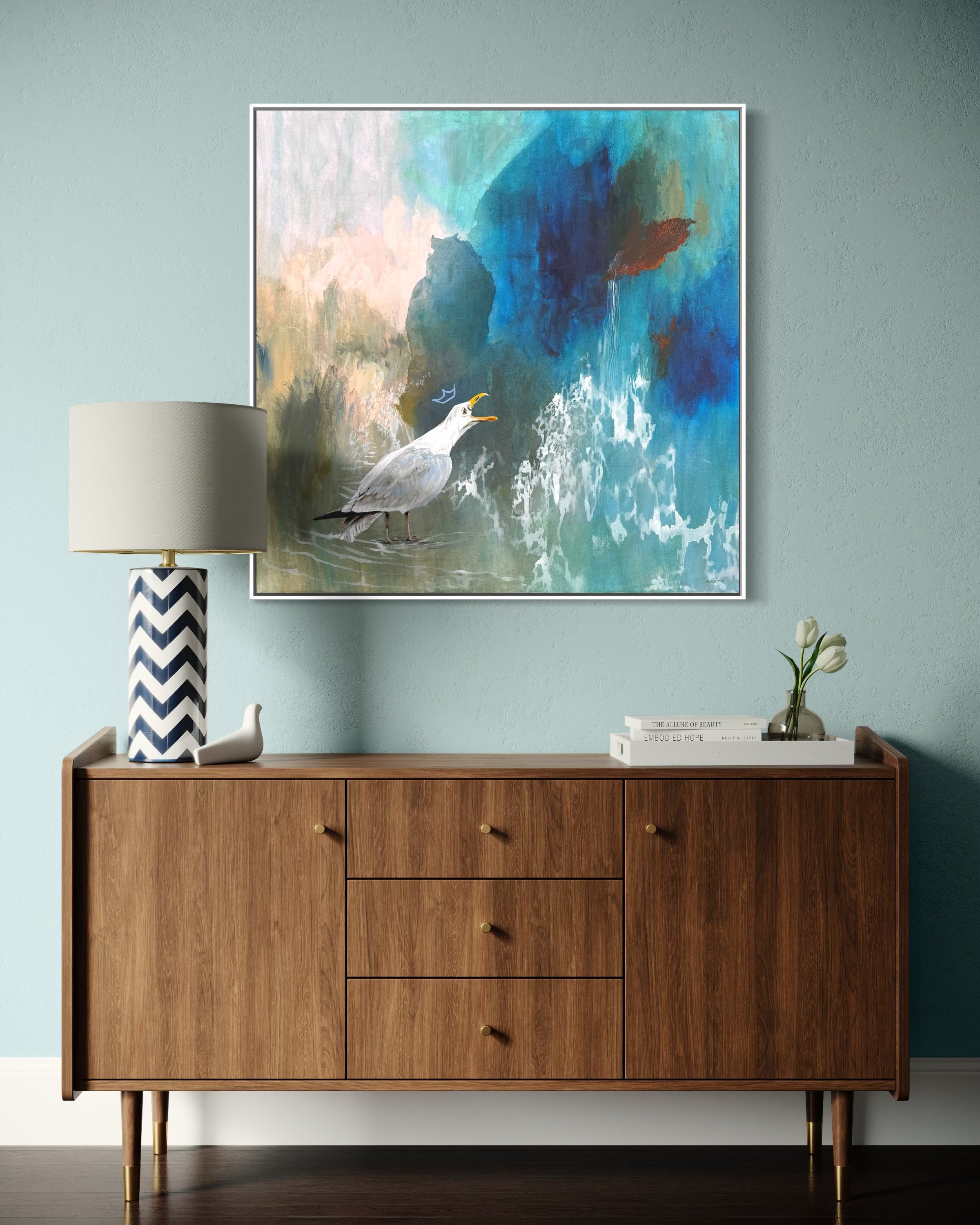large square coastal bird painting over a credenza by Megan Carty