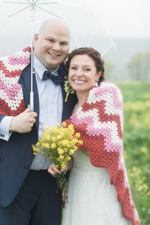 Bride Annie said Chippy’s knitted-afghans saved their wedding, offering cozy accommodations for guests during a summer storm. By her husband Mike's side, Annie’s blue eyes shine bright despite gray skies. Photos by Nicole DuMond's Photography .
