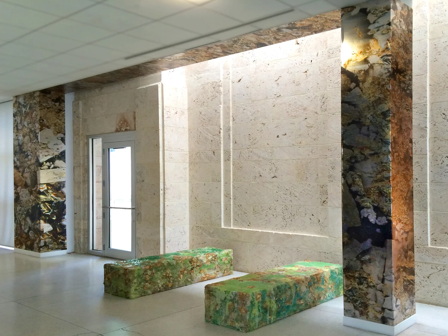 Installation view of Limestone Bearing Gold Veins at The Bass Museum of Art. Metallic wallcovering and handmade benches by Cristina Lei Rodriguez.