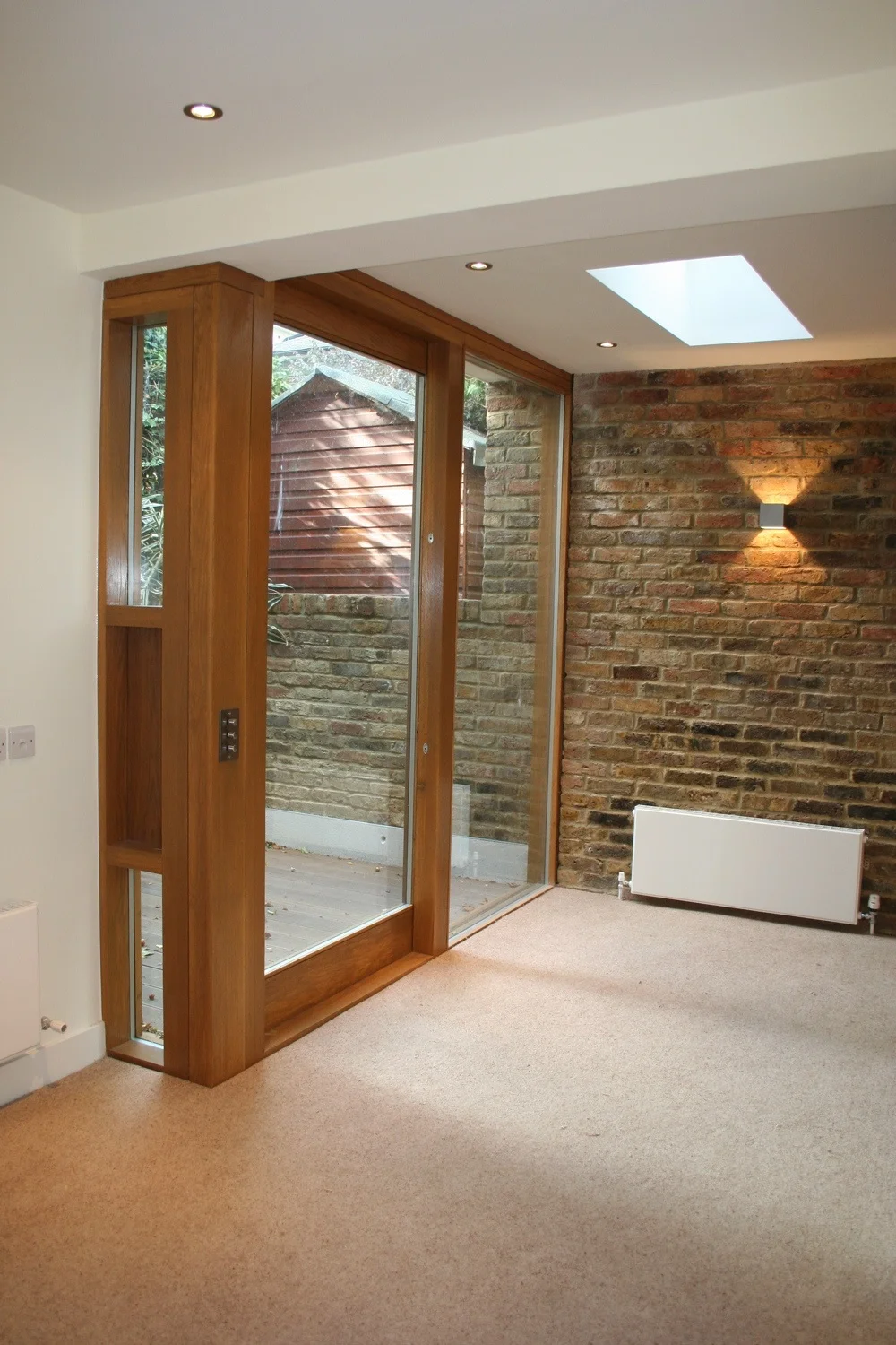 The brief was to develop the property with a ground floor single-storey extension to replace part of the existing unused and neglected external yard, supplying a spacious bedroom with dressing area and renewed bathroom. With a poor northwest facing aspect, lighting design (natural and artificial) was central. Running the London stock facing brickwork past the screen wall of ‘frameless’ fixed glazing (with large sliding door) enhances the connection between interior and exterior space as does matching the levels and colour of the floor finish. Reclaimed London stock brickwork was used as much as possible – as well as being inherently sustainable, this gave a perfect visual match to the existing. Joinery is American white oak from sustainably managed forests. A green sedum roof is planned. © jake ireland architects 2007 - 2015