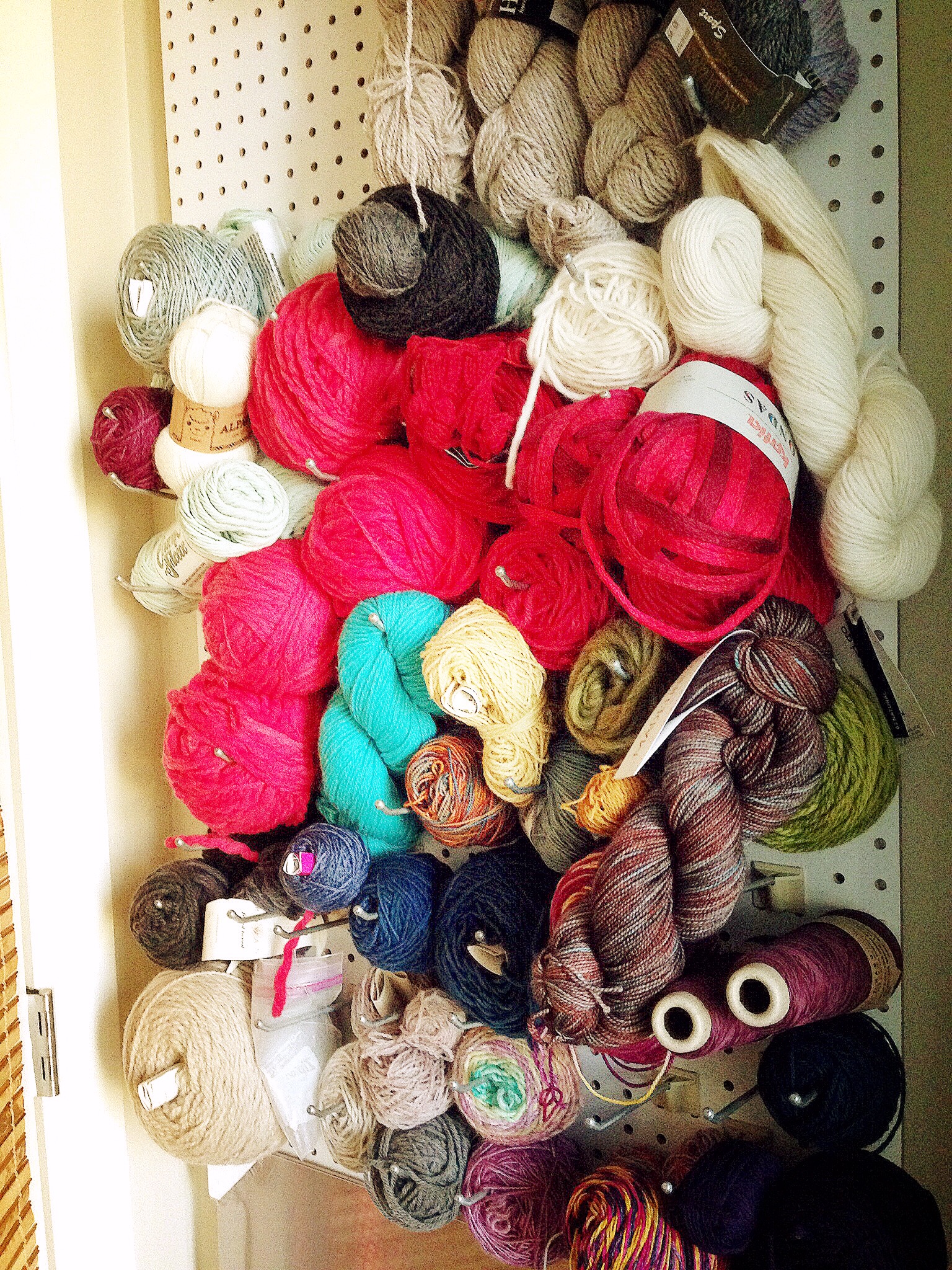 Yarn Wall! The #flufflyblondemonster created this removable peg board for me to store all of my yarn. It hides behind the door and also covers the fuse box for our apartment (which is why it had to be removable) It's a great way for me to visualize my yarn stash and plan projects.