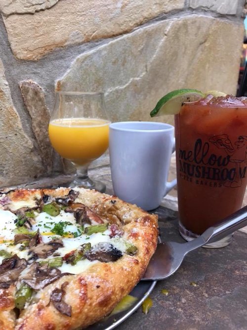 a picture of a vegetable pizza and bloody mary, a mimosa and cup of coffee