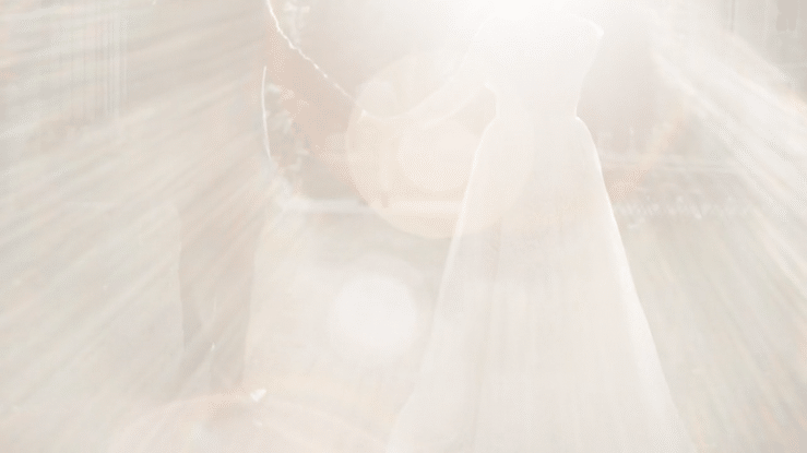 Close-up of a person's hand pouring a liquid into a cup.