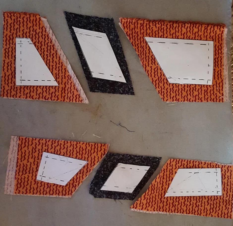 Cutting out fabric pieces using template sections.