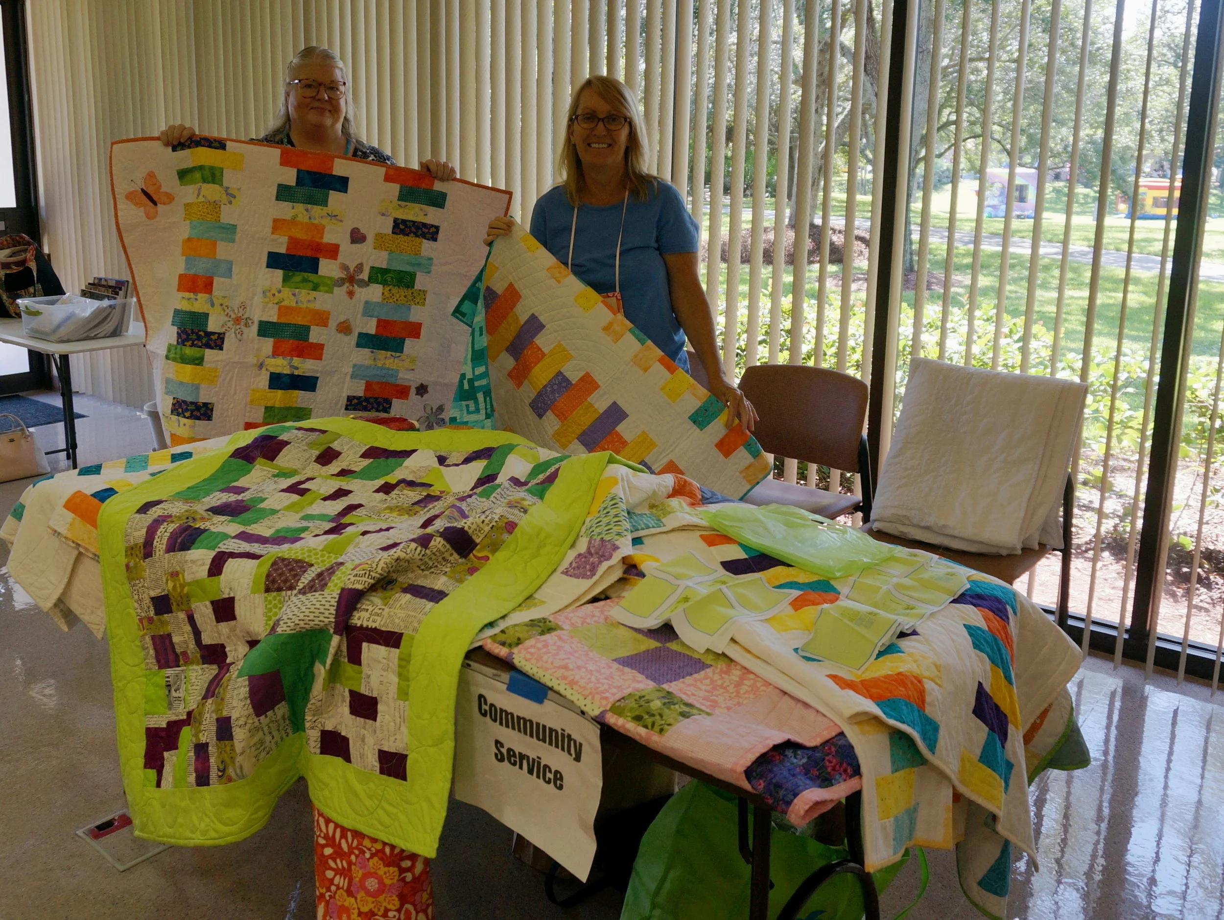 Wanda and Susan show off our quilts for Manor Care nursing home