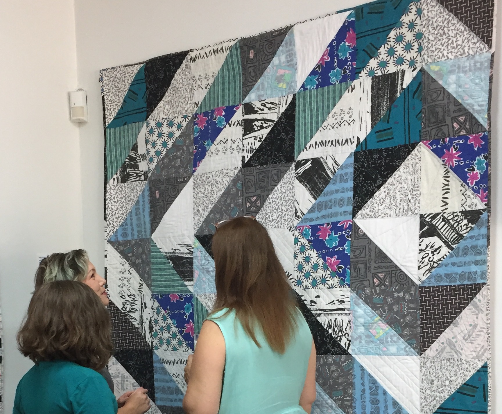  Artist Debby Schindall discussing her quilt with exhibit attendees. 