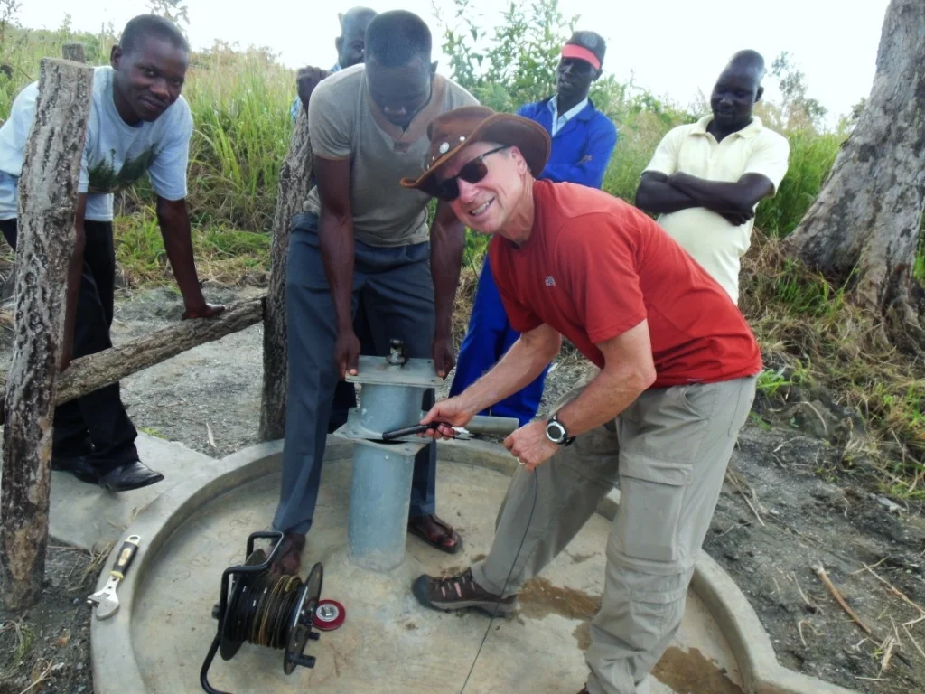 Deploying the Solinst Levelogger transducer into the Opit goat property water well.