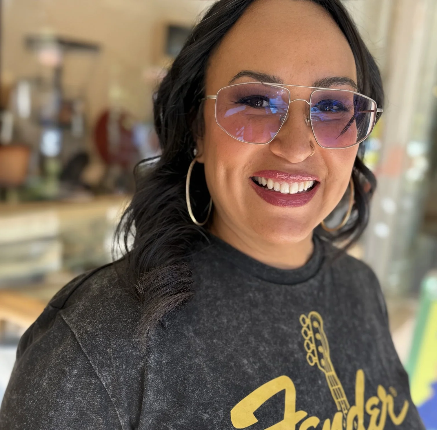 Emily, smiling, wearing glasses and a necklace, captured in a profile picture format.