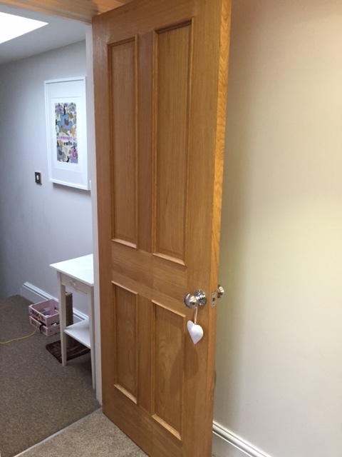Secretly hidden behind the door.