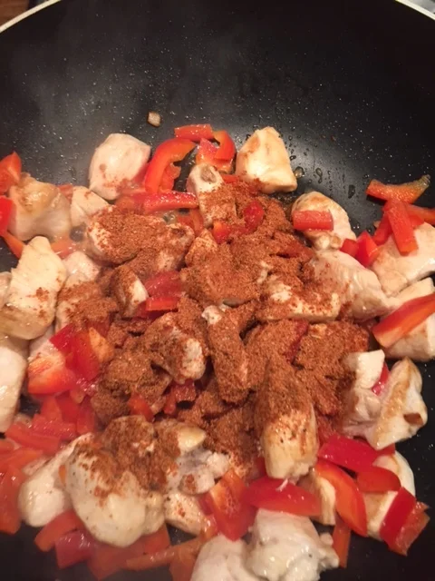 Pop the spice mix on the chicken once it's sealed in the pan.