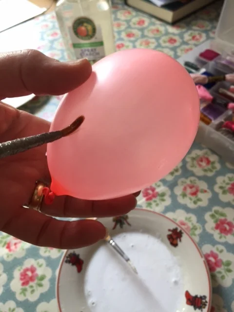 Apply some olive oil to your water balloon before wrapping glue-dipped thread to make balloon removal easier once popped.