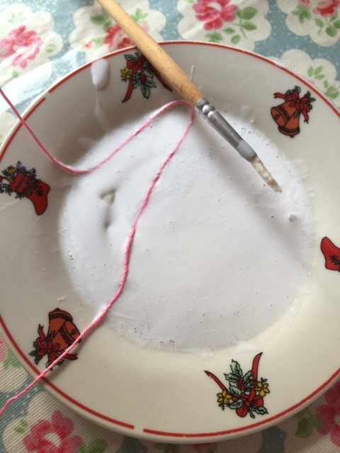 Mix PVA glue with spray starch, then dip thread into the mixture until fully coated.