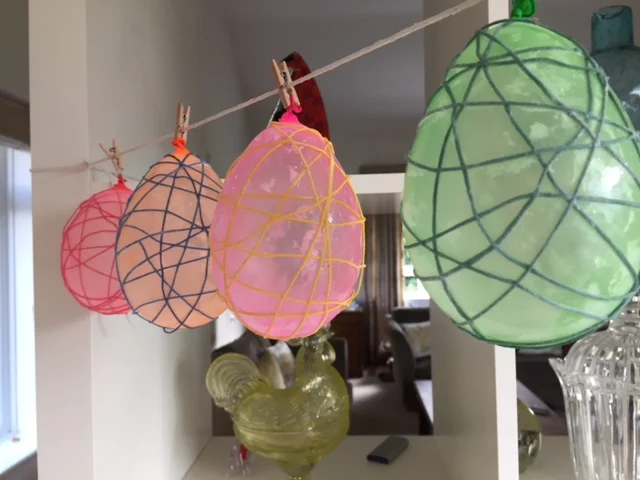 Peg balloons to a makeshift washing line to dry.