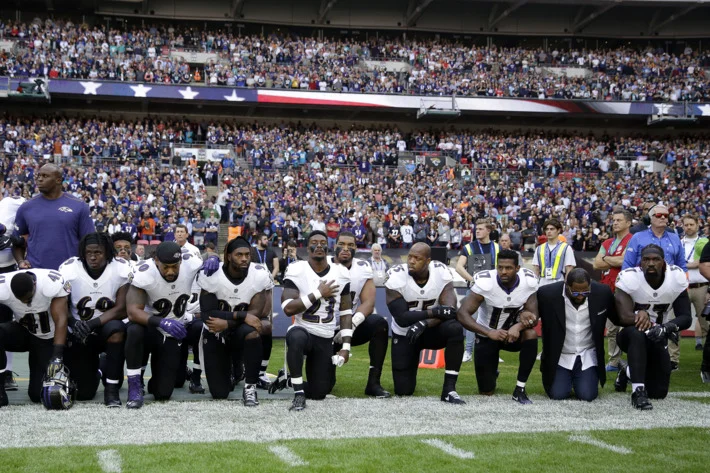 Baltimore Ravens players, including former player Ray Lewis, second from right, kneel down during the playing of the U.S. national anthem before an NFL football game against the Jacksonville Jaguars at Wembley Stadium in London on Sunday. Photo: Matt Dunham/AP