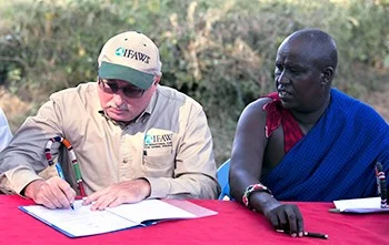 Azzedine Downes, IFAW President (left) and Mr. Daniel Leturesh, representing the Masai community, sign the Kitenden corridor certificates after they signed a lease agreement, 17 July 2013, in Amboseli National Park in Kenya. © IFAW/K. Prinsloo