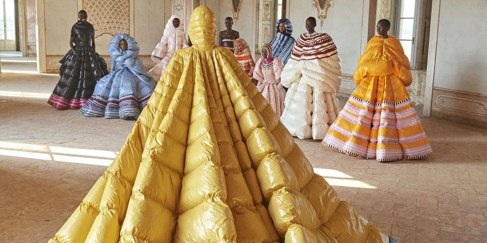 Bringing their "Moncler Genius" design series to Milan Fashion Week for a second time, the brand unveiled a series of avant garde puffer coats in collaboration with designers including Richard Quinn, Simone Rocha, and Valentino's Pierpaolo Piccioli. Standing out as the most grandiose of them all was the capsule with Piccioli, which brought forth a series of dramatic puffer couture gowns. Done in collaboration with model Liya Kebede, the Moncler x Piccioli gowns tapped eight Ethiopian artists from Kebede's ethical fashion brand, Lemlem , to bring the designs to life. The end result? A breathtaking collection of colorful puffer coat gowns that would make any of us happy to bundle up. Image via Harper’s Bazaar