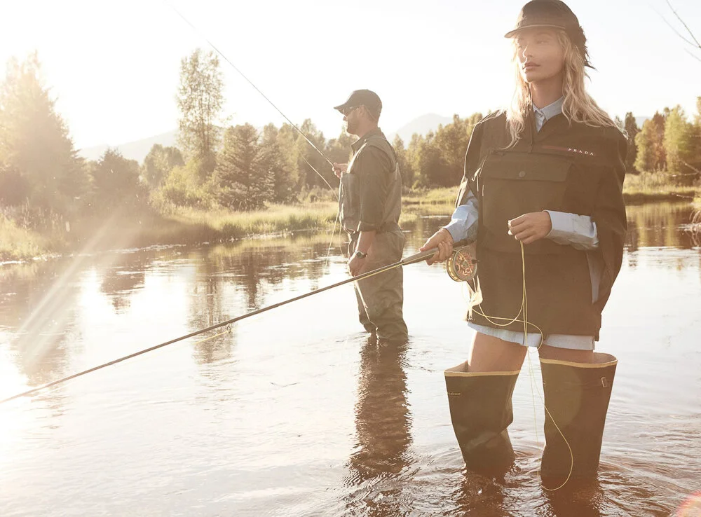 Hailey Bieber by Daniel Jackson, Vogue , October 2019. via Vogue.com. Bieber (with WorldCast Anglers guide Mikey Hemkens) casts a line in a Prada jacket ($2,130), shirt ($690), and hat; select Prada stores. LaCrosse boots.