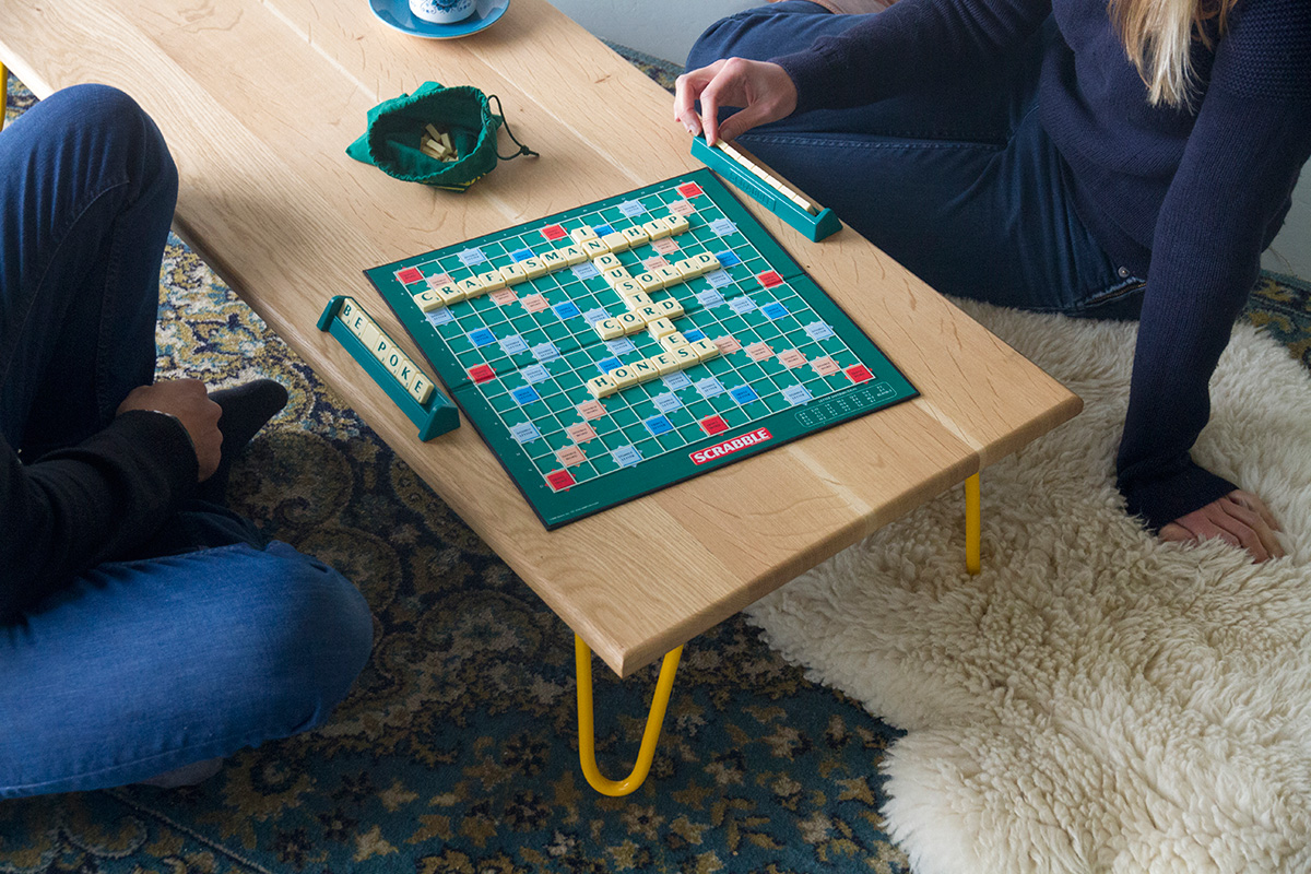 Cord Industries hairpin leg coffee table in oak with yellow legs - shown with scrabble board.