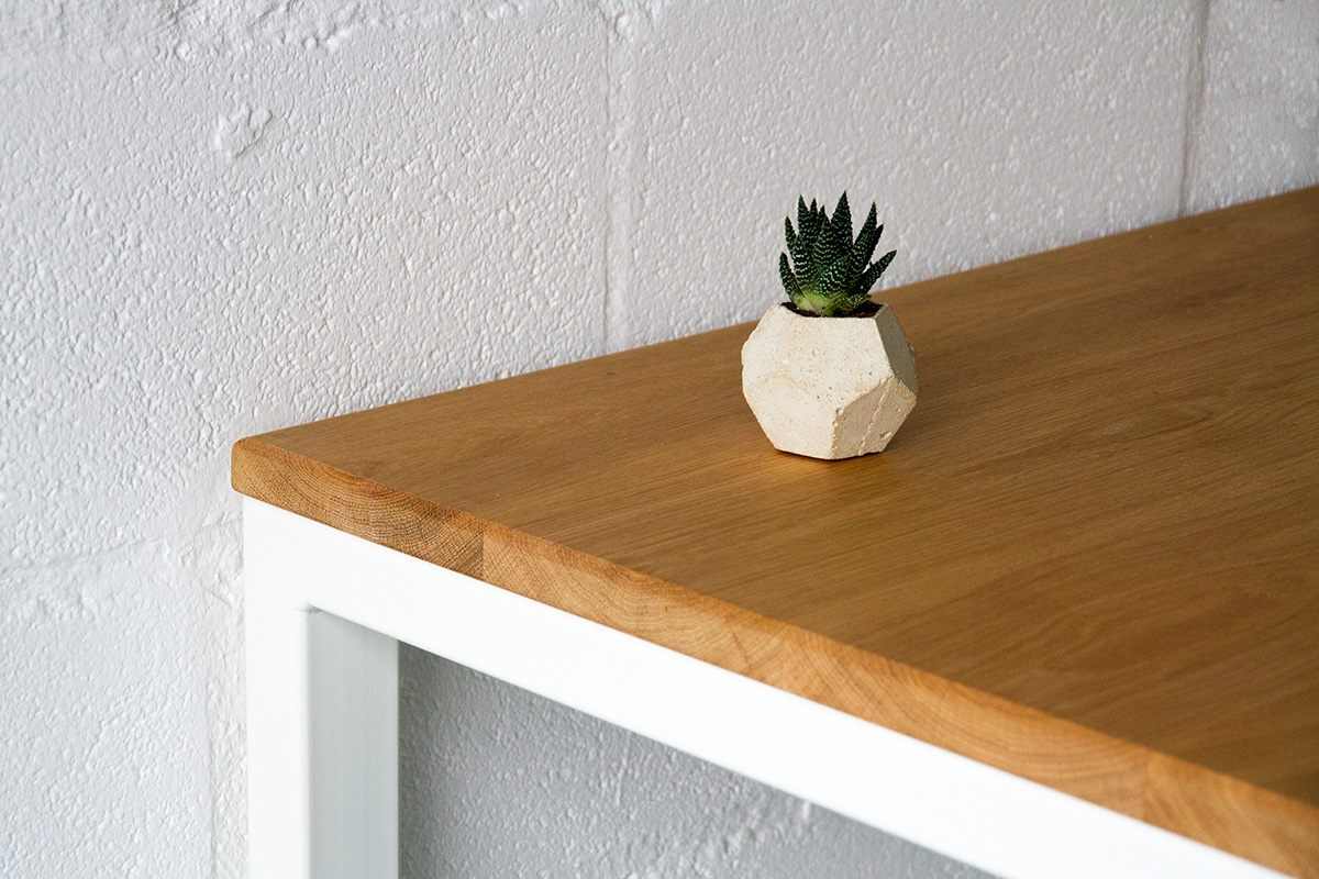 Cord Industries Nola desk table in oak with white legs (close-up).