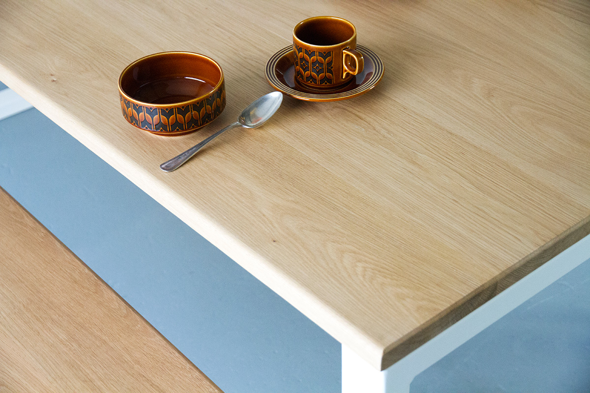 Cord Industries Nola dining table in oak with white legs (close-up).