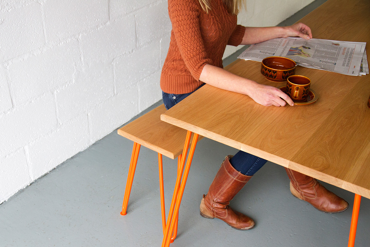 Cord Industries hairpin leg dining set for six, in oak with orange legs.