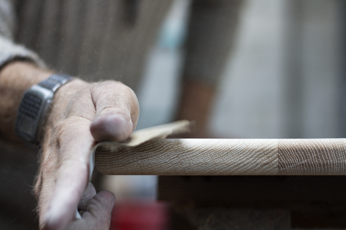 Oak coffee table top being sanded at the Cord Industries workshop.