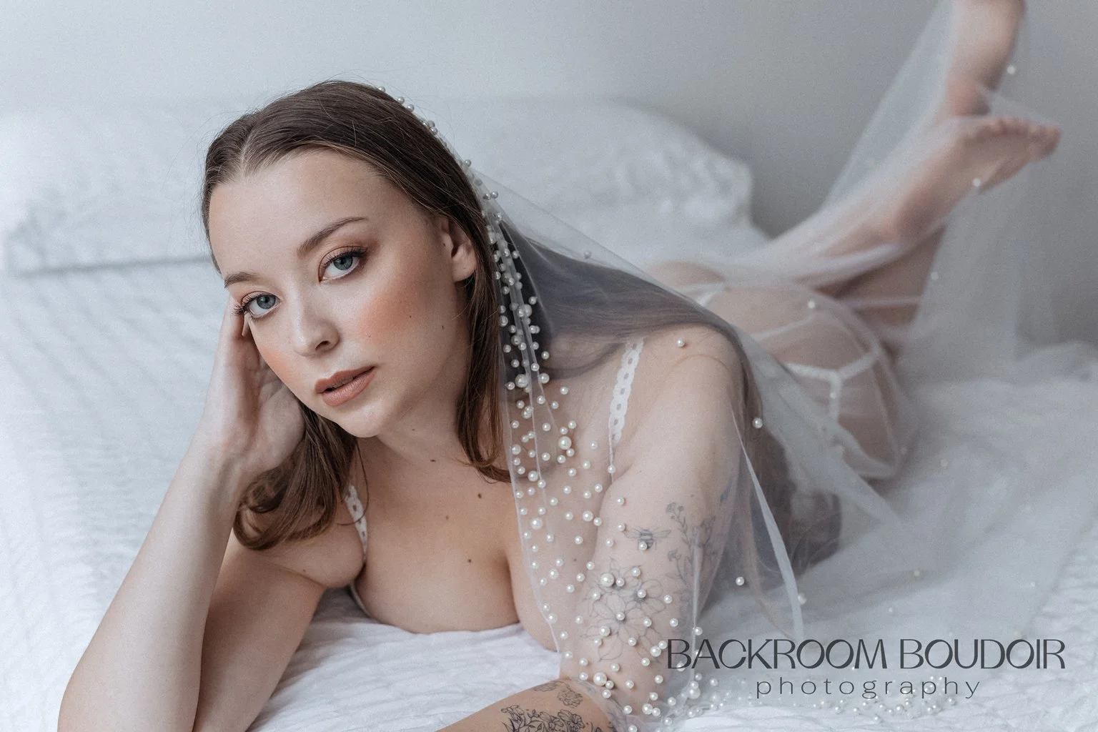Woman in a veil poses seductively on a bed