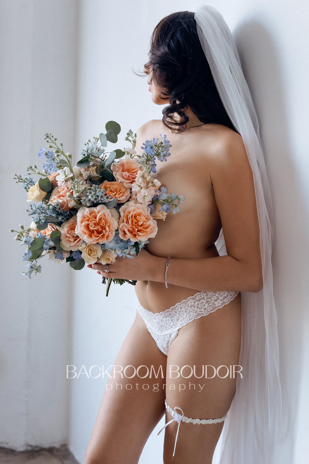 Bride covering her breasts with her wedding bouquet