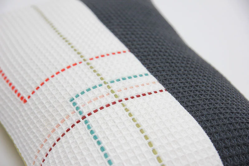 Hand embroidered organic cotton navy and white rectangle cushion detail