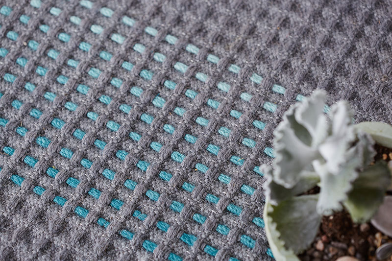 Turquoise hand embroidery on grey base