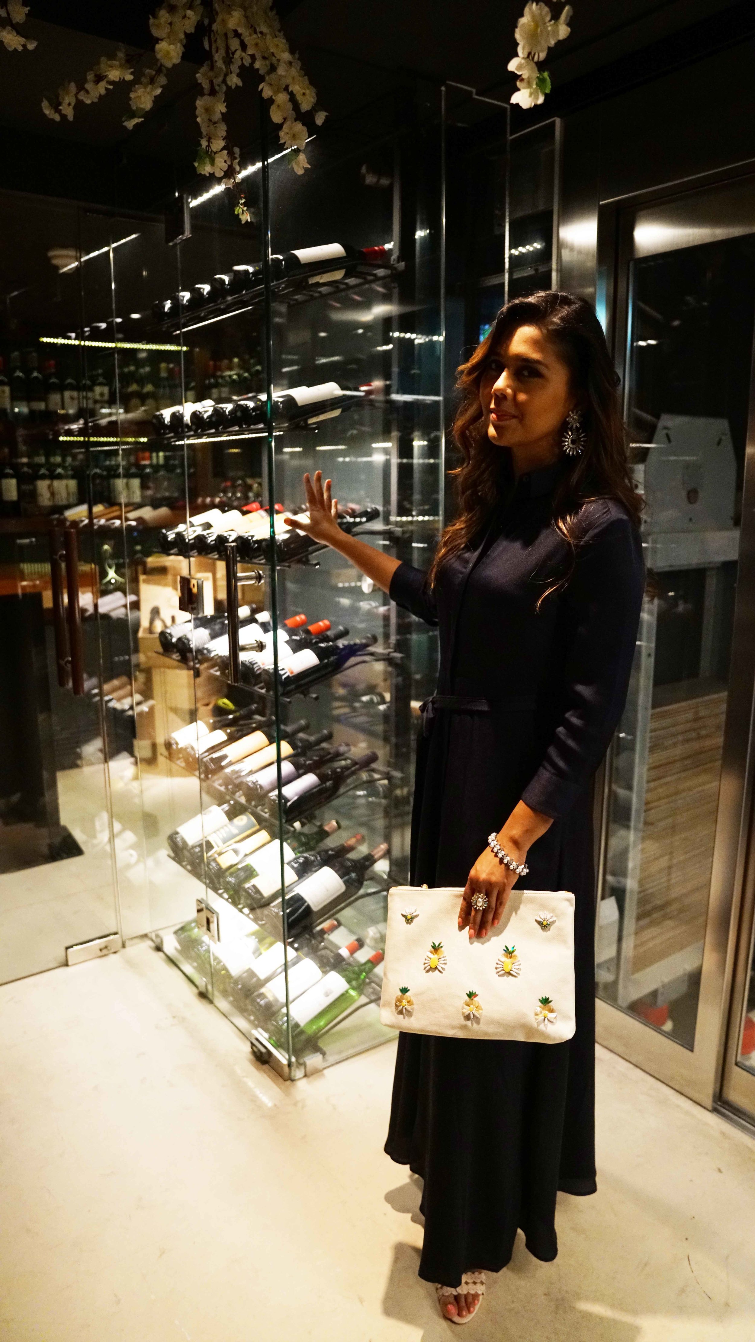aN ELEGANT JUMPSUITE PAIRED WITH OVERSIZED METAL AND STONE STUDDED EAR-RING AND RINg. a CLASSY PEARL BRACELET TO ADD TO THE ELEGANCE AND A CASUAL JUTE Pineapple zip pouch TO MIX IT up. (Hair styled by beBar, Jumeirah Beah Road) .