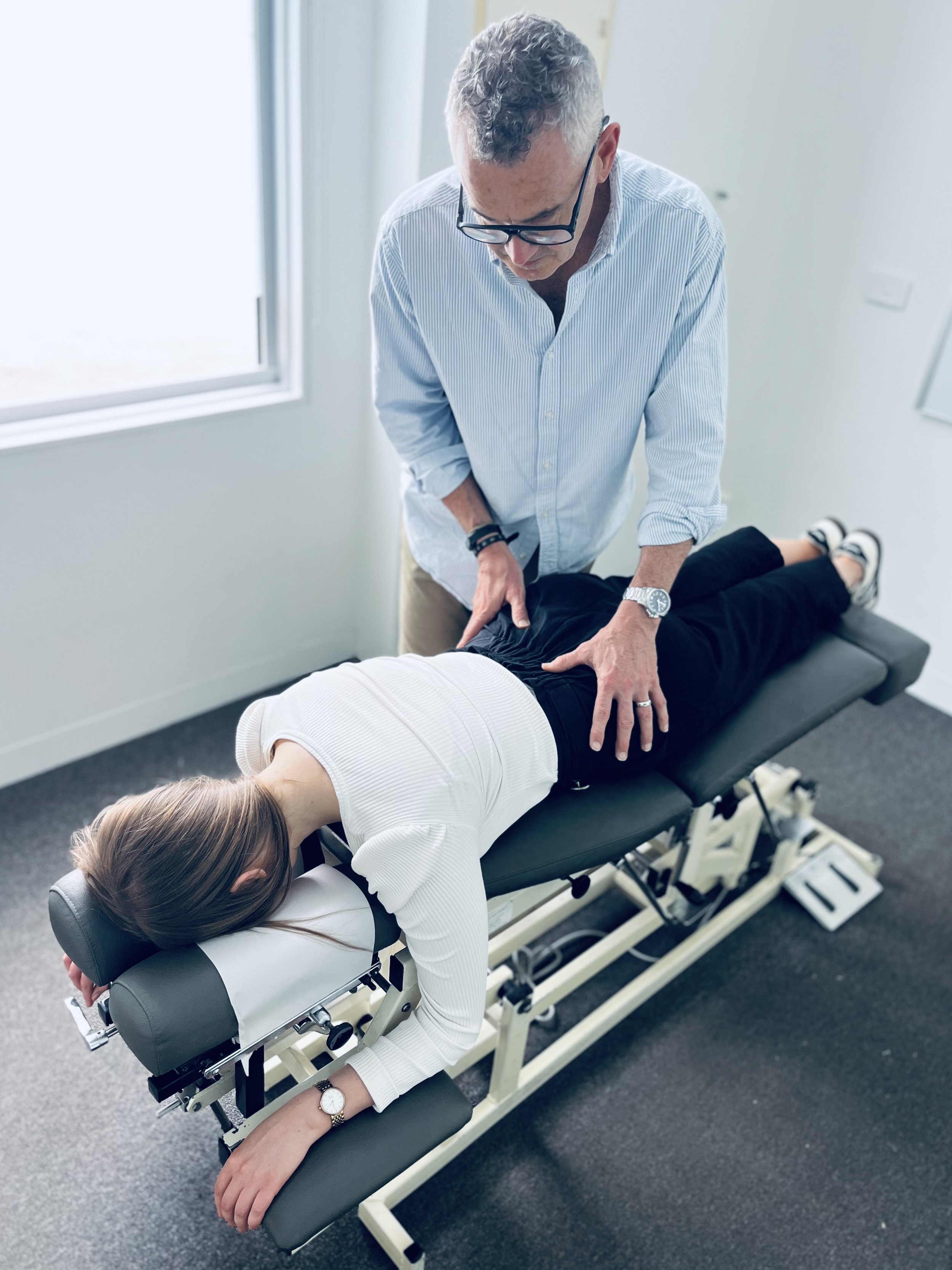 A chiropractor palpating the pelvis