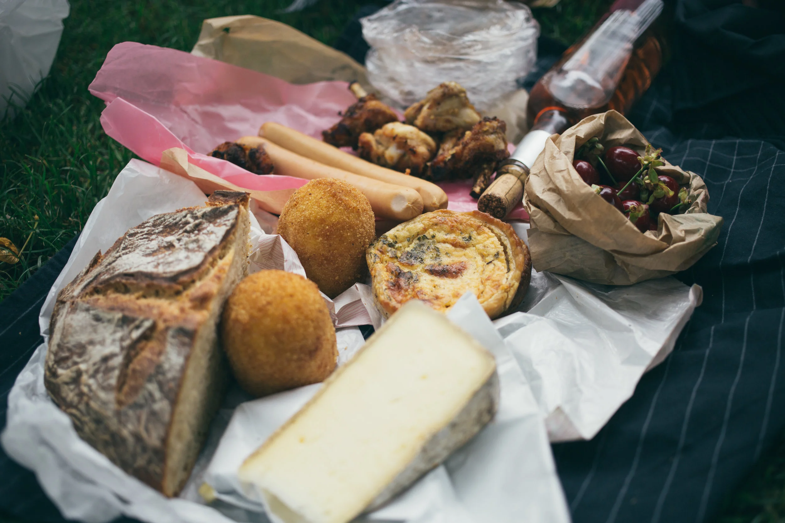 Bread, cheese and various items on the grass ready for a Picnic in Paris