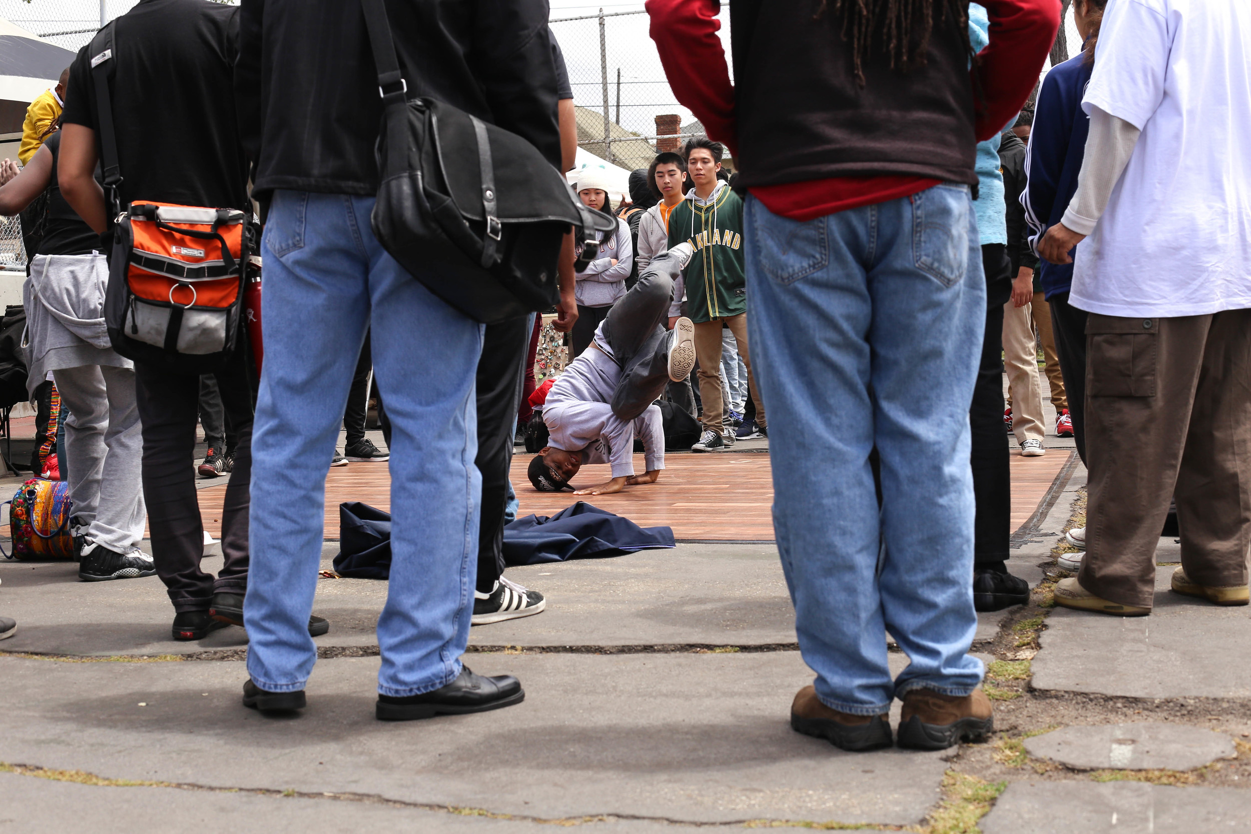 A crowd forms around a breakdancer.